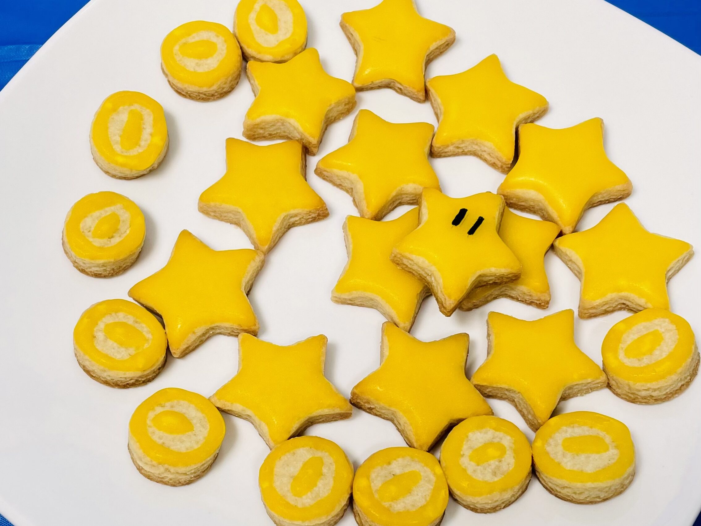 Galletas inspiradas en Mario Bros, con sabor a mantequilla y forma de estrellas y monedas, cubiertas con glaseado amarillo.