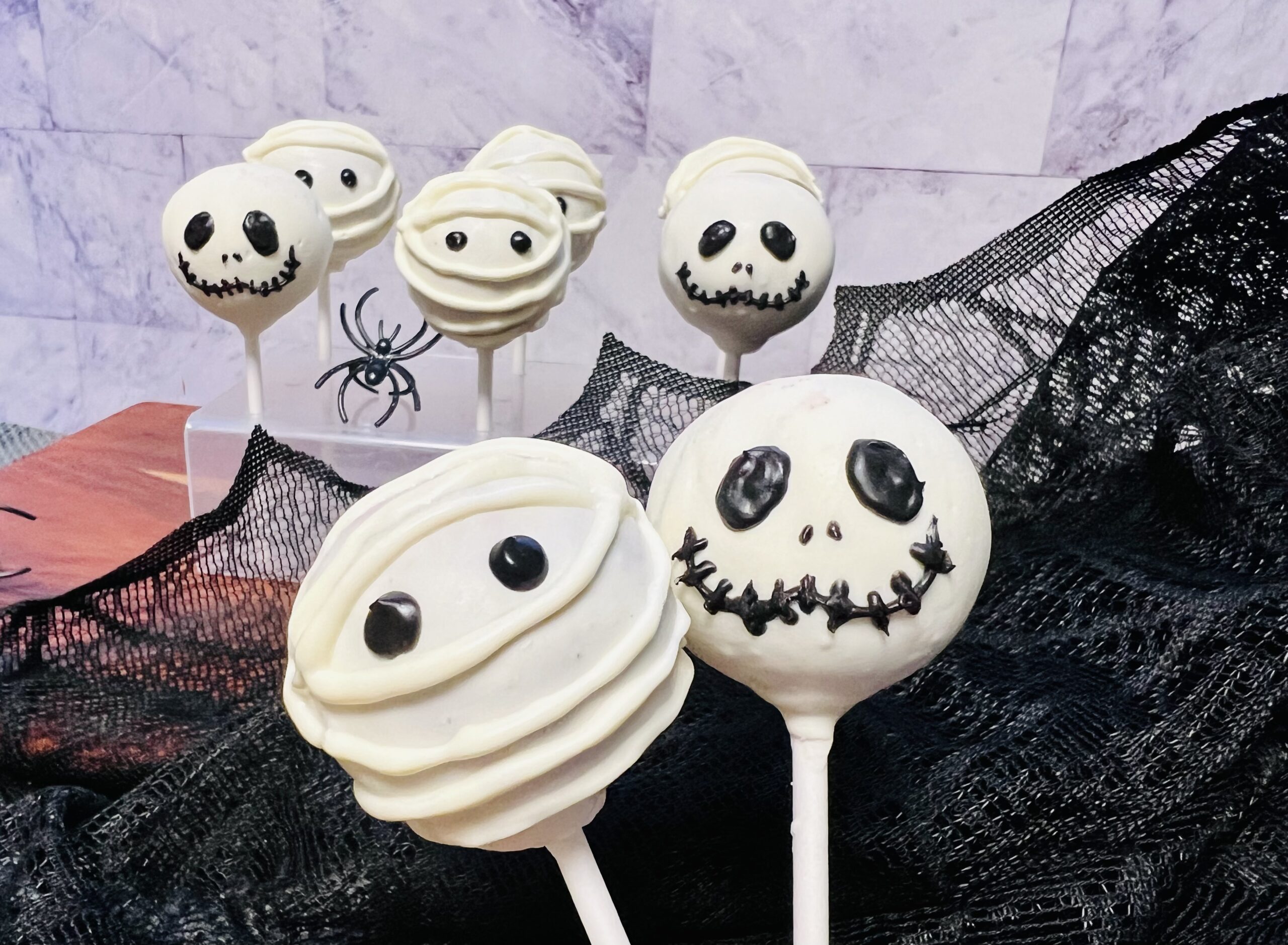 La imagen muestra unas cake pops monstruosas decoradas como momias y como Jack Skellington del extraño mundo de Jack