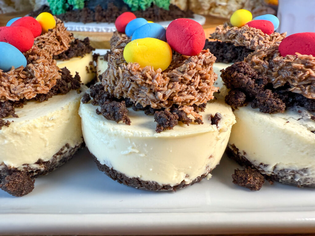 Imagen de un plato con mini pays de queso con oreo, decorados con nidos de chocolate y huevitos de fondant de color amarillo, azul y rojo que simulan nidos de dragón.